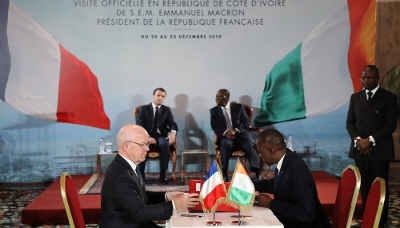 Philippe Bonnave, ex-CEO of Bouygues Construction (left), and Ivorian Minister of Transport Amadou Koné sign Abidjan metro project in the presence of French President Emmanuel Macron and Alassane Ouattara in Abidjan, in December 2019. 