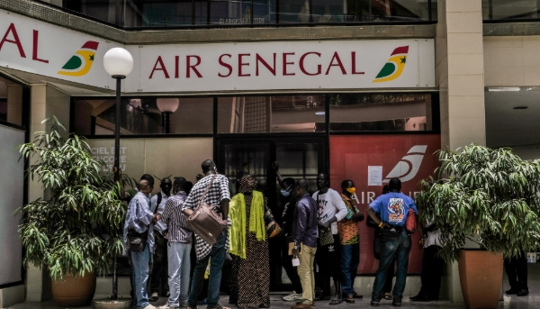 Customers wait outside an Air Senegal ticket office in Dakar on 21 July 2020.