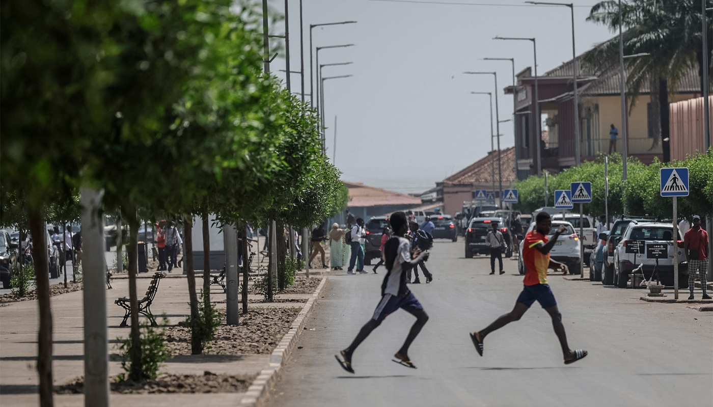 People flee the scene as gunfire rings out near the Presidential Palace in Bissau, 26 November 2025.