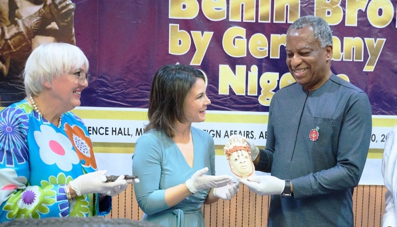 German ministers Claudia Roth (left) and Annalena Baerbock (centre) return an ivory mask to Nigerian Foreign Minister Geoffrey Onyeama, 20 December 2022.