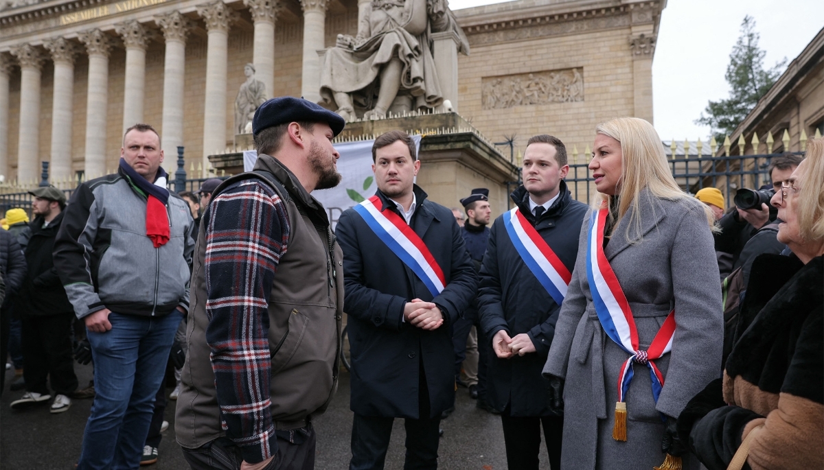 Rassemblement National MP Hélène Laporte (2R) speaks with farmers in front of the French National Assembly in Paris on 8 January 2026.