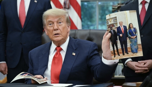 Donald Trump with a photo of himself alongside Rwanda and DRC's foreign ministers, in Washington, 27 June 2025