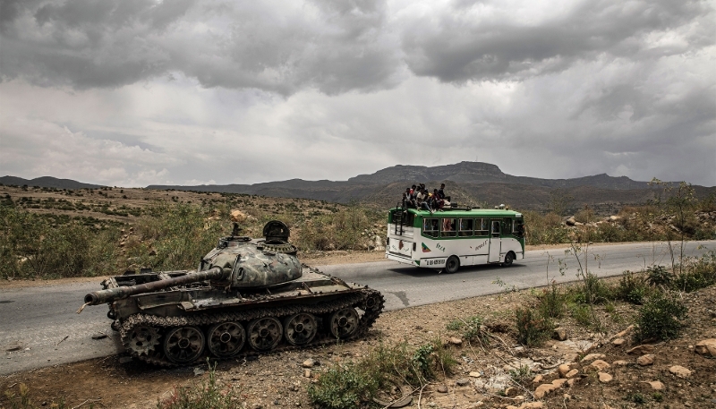 A bus carrying civilians passes a destroyed tank outside Mekele in Ethiopia's Tigray region, in June 2021. 
