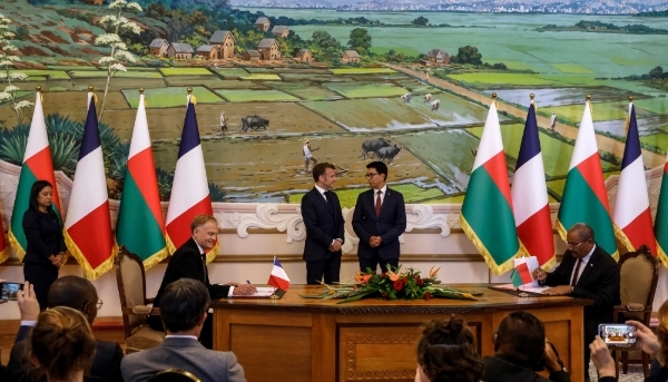 CEO of Volobe General Hydroelectricity Company (CGHV) Remy Huber and Madagascar's Minister of Energy and Hydrocarbons Olivier Jean-Baptiste, in front of French and Malagasy presidents Emmanuel Macron and Andry Rajoelina, respectively, in Antananarivo on 23 April 2025.
