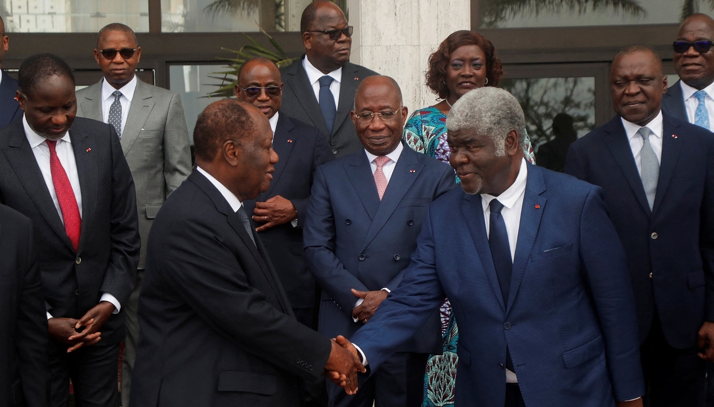 Alassane Ouattara shakes hands with the new prime minister, Robert Beugré Mambé, at the new government's first Council of Ministers meeting on 18 October 2023.