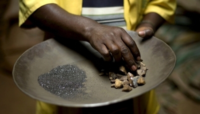 A worker handles coltan and cassiterite ore at a processing plant in the DRC.