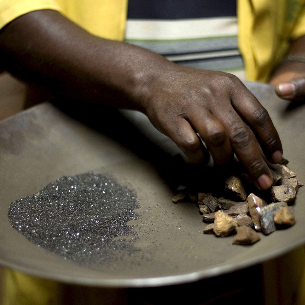 A worker handles coltan and cassiterite ore at a processing plant in the DRC.