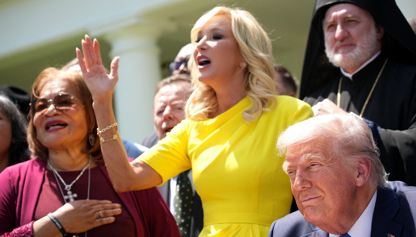 Paula White, head of the Office of Faith at the White House, alongside US President Donald Trump and other religious leaders during a ceremony held on National Day of Prayer, 1 May 2025, in Washington, DC.