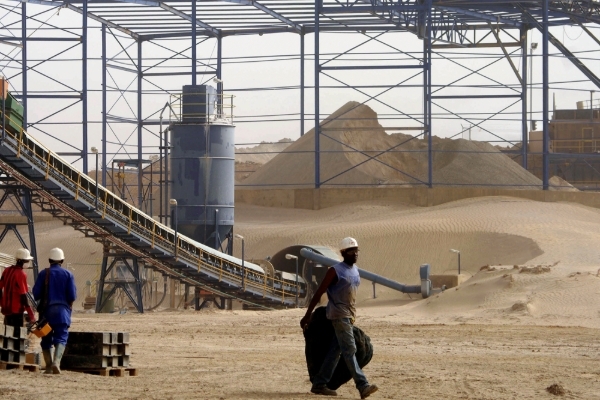 Workers in front of a gold ore stockpile at the Taparko gold mine site, northern Burkina Faso, 11 March 2009.