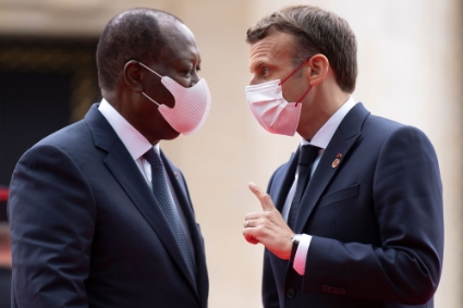 French President Emmanuel Macron (R) greets Ivory Coast's President Alassane Ouattara as he arrives at the Grand Palais Ephemere for the Financing of African Economies Summit in Paris, 18 May 2021.