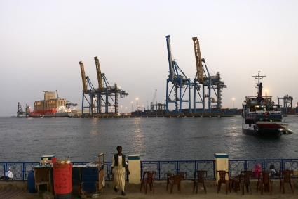 A man stands opposite the modern port at the harbour in Port Sudan.
