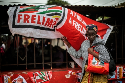 A Mozambican woman by a banner for the ruling Frelimo party before the general elections, Maputo, 10 October 2014.