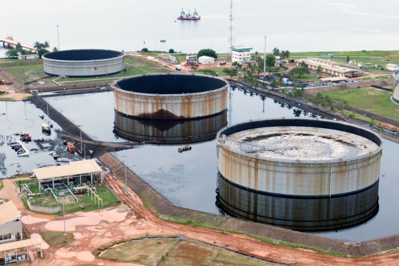 Storage tanks at the Cap Lopez oil terminal in Gabon, surrounded by a pool of crude oil.