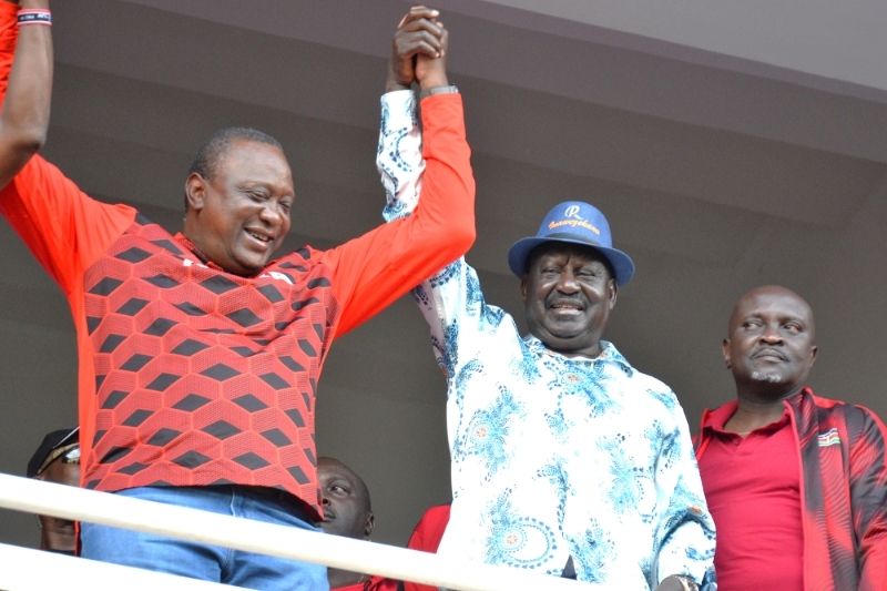 Raila Odinga (blue hat) with President Uhuru Kenyatta (in red on his right) at the Moi International Sports Centre on 8 May 2022.