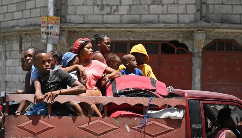 Locals evacuate the Carrefour Feuilles commune in Port-au-Prince, Haiti, as gang violence continues, 15 August 2023.