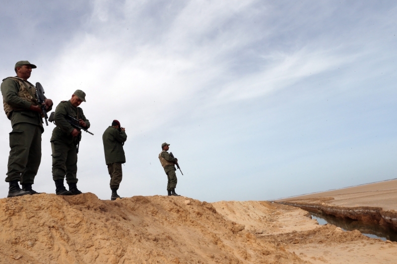 Tunisian soldiers stand on a sandbank of the anti-jihadi fence, near Ben Guerdane, eastern Tunisia, close to the border with Libya, the 6th of February 2016.