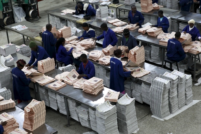 Workers arrange copies of the Business Daily newspaper produced by the Nation Media Group at a printing press plant on the outskirts of Kenya's capital Nairobi, 24 November 2015.
